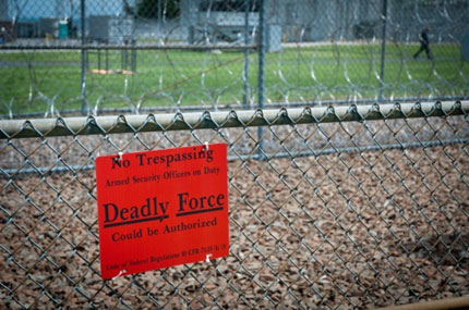 red warning sign on fence stating 'No Trespassing - Armed Security Officers on Duty - DEADLY FORCE could be authorized' - Code of Federal Regulations 10 CFR 73.35 (h) (5)